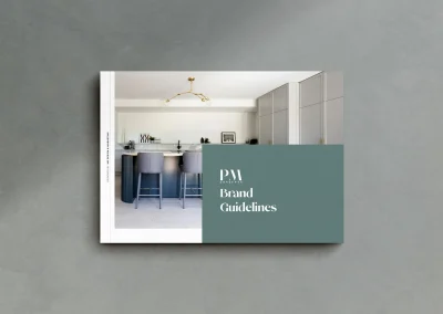 PM Brand Guidelines booklet on gray surface, showing modern kitchen; highlights Aloe Rentals' elevated Brand and Web Design Gold Coast.