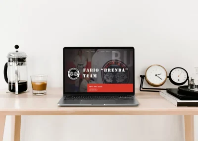 Modern workspace with laptop showing martial arts site, coffee, Aloe Rentals brochure—Brand and Web Design Gold Coast expertise.