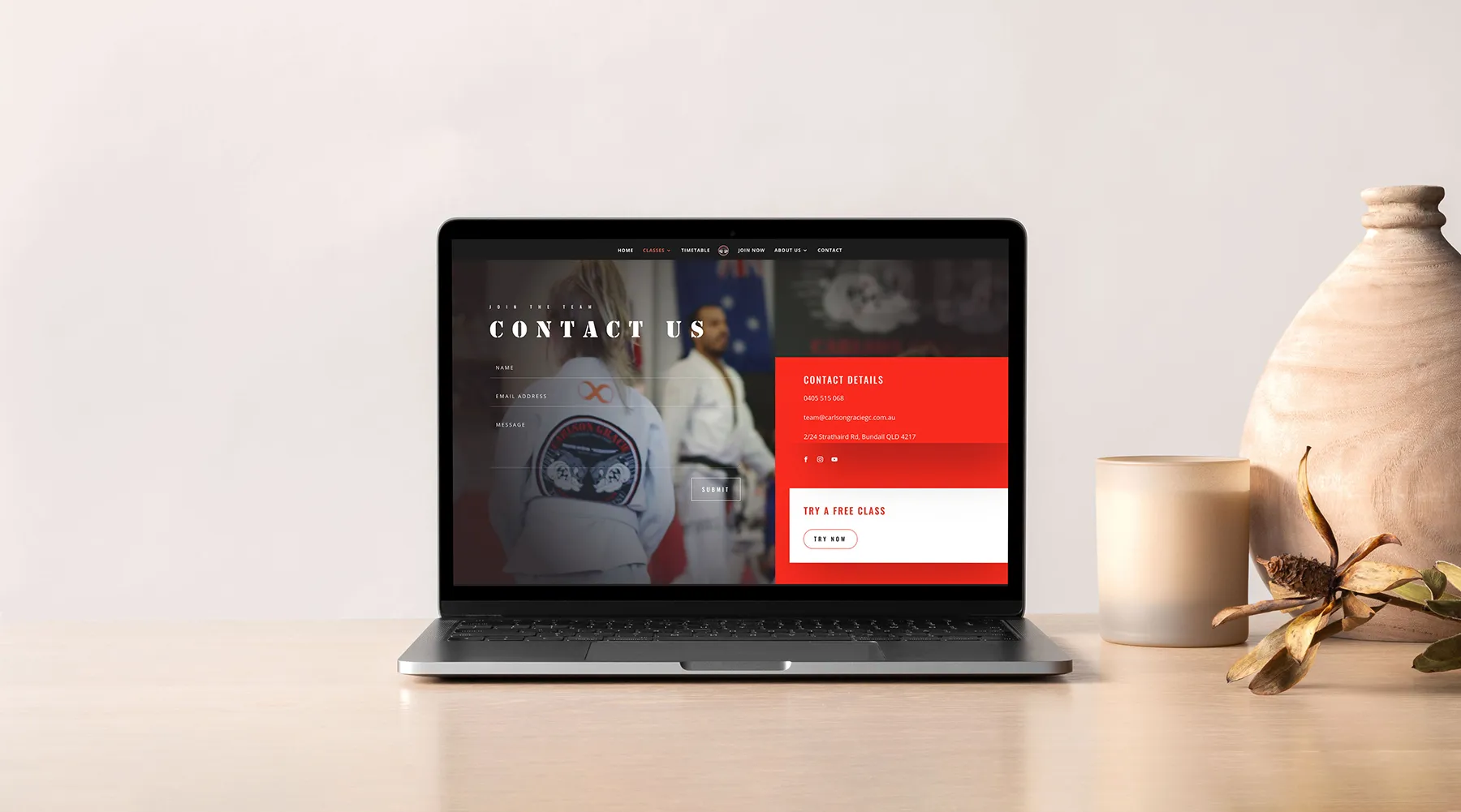 Carlson Gracie Gold Coast website displayed on a laptop in a workspace setting. Bjj website design